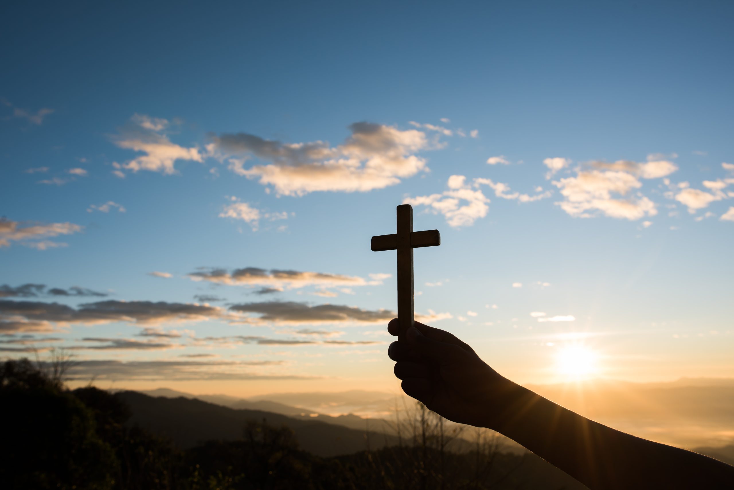 Silhouette of Hand hold cross of God